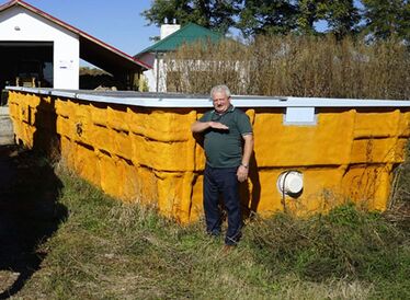 Daragus Attila polgármester a medence vizének magasságát mutatja (Bartos Lóránt felvétele)